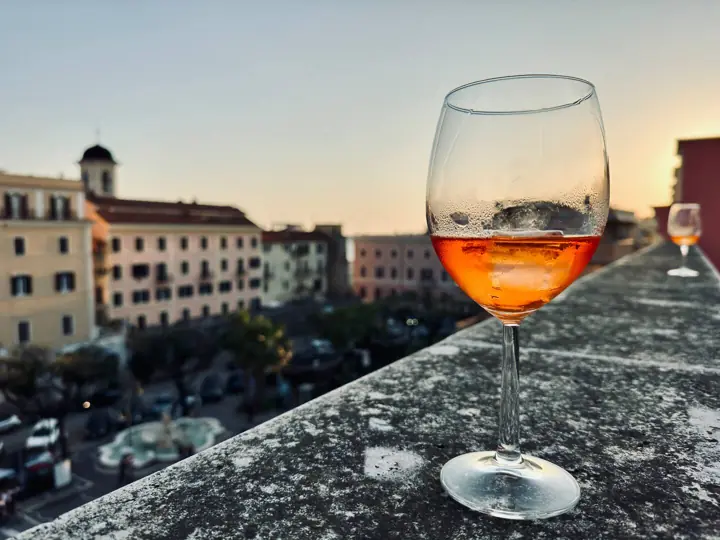 Aperitivo al tramonto sul davanzale, con la fontana sotto
