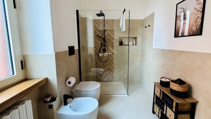 Bagno con doccia walk-in e piastrelle effetto marmo